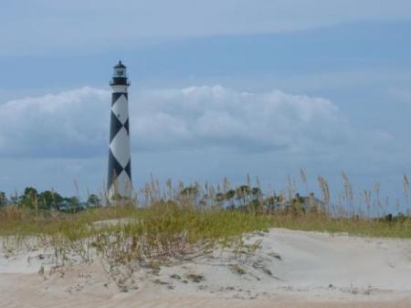 Beach with lighthouse in the distance.