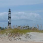 Beach with lighthouse in the distance.