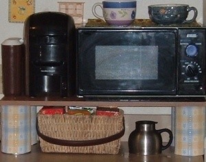 microwave shelf made from decorated cans and a board