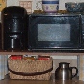 microwave shelf made from decorated cans and a board