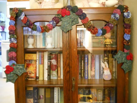 Garland hanging draped on antique wooden bookcase.