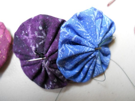 Sewing center string through yo yos.