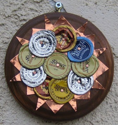 A sun ornament made from bottle caps.