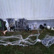 Tombstones outside of home decorated with spider webbing, skeletons, etc.