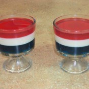 Two clear dishes of red, white, and blue Jello parfait.