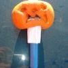 A mini pumpkin on a flashlight.