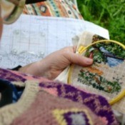 A woman doing cross stitch.