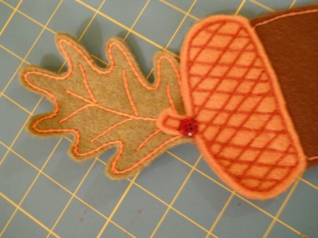 Attaching leaf to large acorn with button.