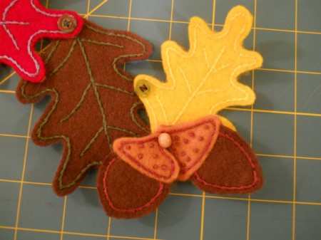 Connection small acorns to bottom of wall hanging.