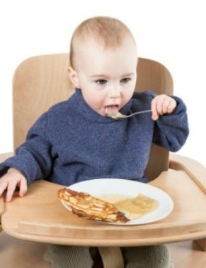 Eating pancakes with applesauce.