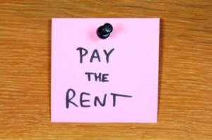 Sticky note reminder to pay the rent.
