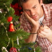 A man repairing Christmas tree lights.