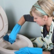 A woman cleaning a toilet.
