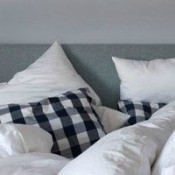 A bed with pillows and a comforter