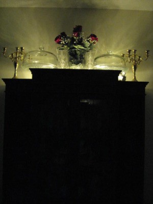Lights on top of cabinet, reflecting off wall.