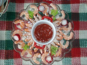 A plate of shrimp appetizers around cocktail sauce