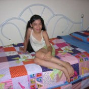 Young girl sitting on her bed with birthday quilt.