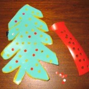 tree shape cut from a green laundry soap bottle with ornaments punched from a red one