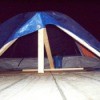 Pup tent with blue tarp for dog shelter.
