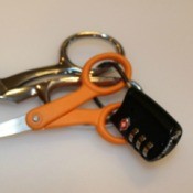 A lock attached to two pairs of nice scissors.