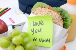 A packed lunch with a sandwich and grapes.