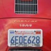 The rear license plate of a red car from California.
