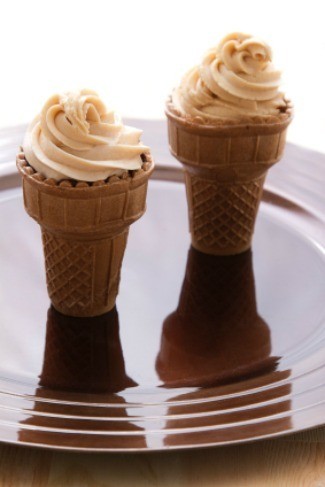 Cupcake baked in ice cream cones with frosting on top.
