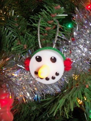 Snowman ornament with light-up nose.