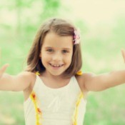 a young girl holding up both hands
