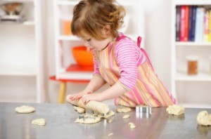 A toddler making cookies.