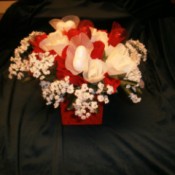 Red and white silk flowers in red box.