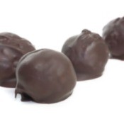 A row of chocolate cover peanut butter balls.