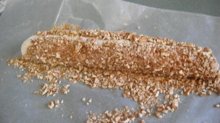 Pressing caramel and nuts around the marshmallow center.