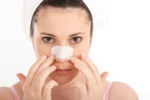 A woman with a pore strip on her nose.
