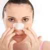 A woman with a pore strip on her nose.