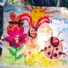 Cardboard drawing of flower, sun, bunny, and ladybug with holes for faces.