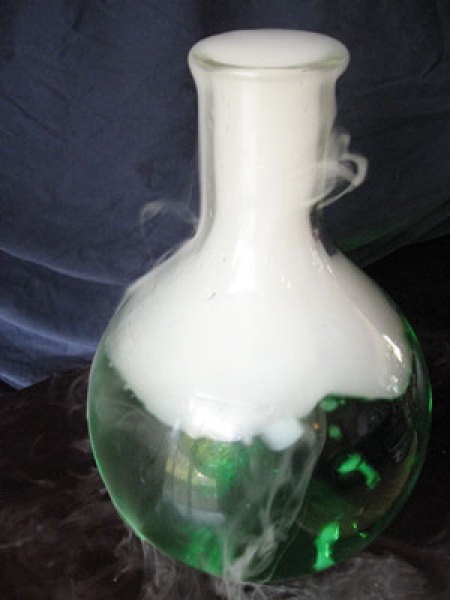 A flask with green water and dry ice.
