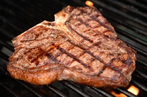A T-bone steak on a grill.