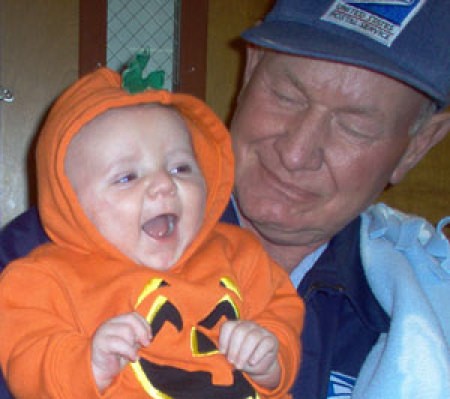 A child dressed as a pumpkin with a man.