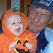 A child dressed as a pumpkin with a man.