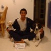 Teen sitting with Scruffy and another dog, with Happy Birthday sign on floor.