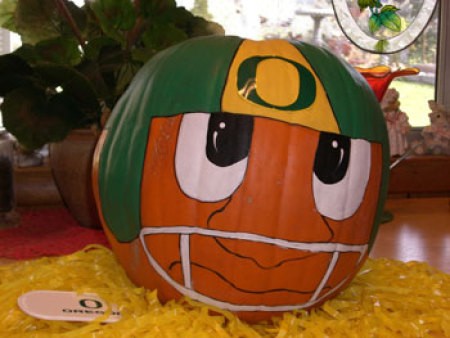 A pumpkin painted with an Oregon Ducks helmet.