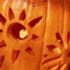 A flower or sun pattern carved into a pumpkin.