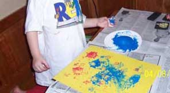 Child making print art.