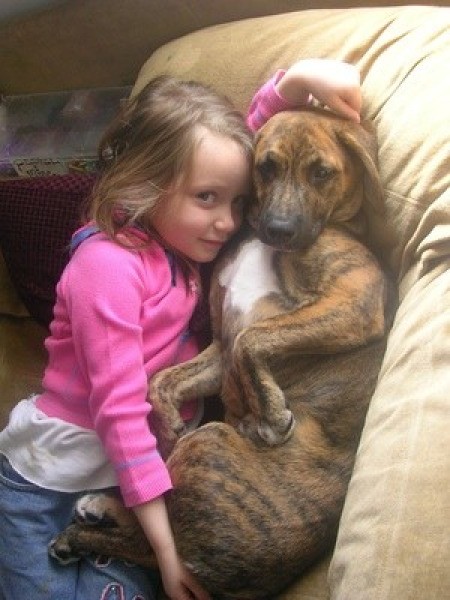 Sasha on couch with young girl.