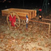 Wooden wagon with large red bow on wheel.