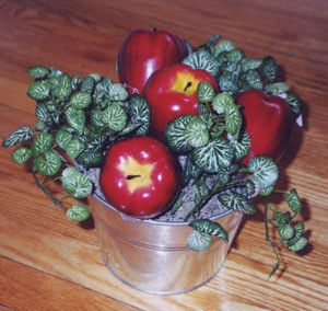 Apples and faux greenery in pail