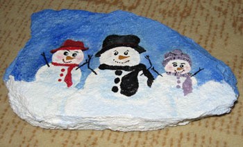 Rock painted with three snowmen.