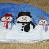 Rock painted with three snowmen.