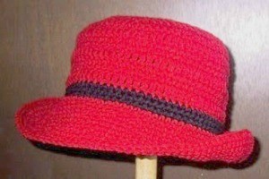 Closeup of a red crochet hat with brim.